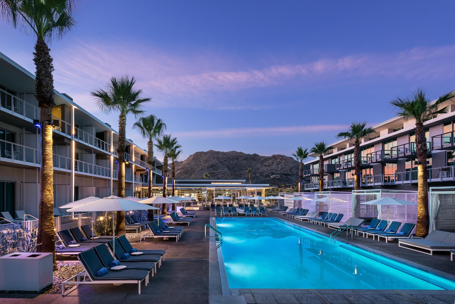 Mountain Shadows Citizens Club pool at dusk with palm trees and Camelback Mountain